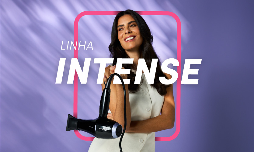 Mulher feliz segurando difusor de cabelo WAP Linha Intense em fundo roxo.