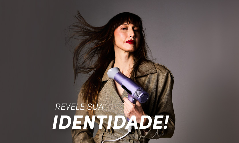 Mulher com cabelo solto segurando secador WAP lilás e revelando sua identidade.