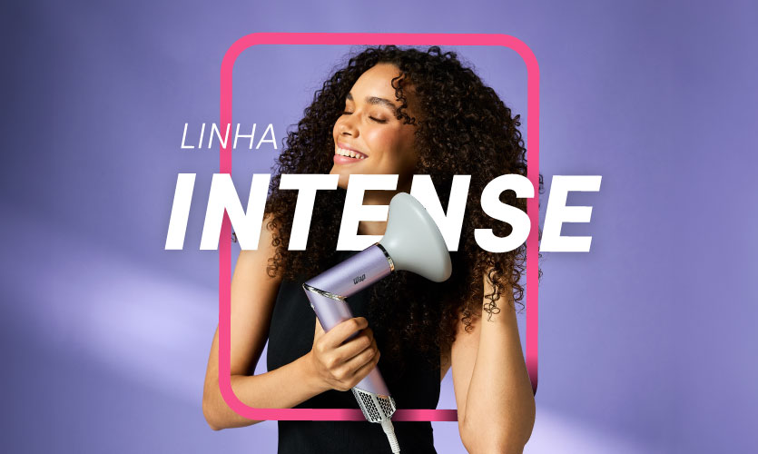 Mulher sorrindo segurando secador de cabelo WAP Linha Intense em fundo roxo.