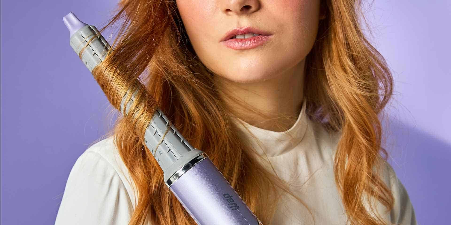 mulher segurando prancha de cabelo