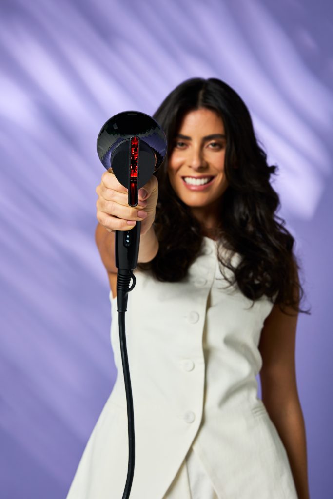 Mulher segurando um secador de cabelo moderno